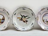 trois assiettes avec l'image d'une femme et d'un oiseau