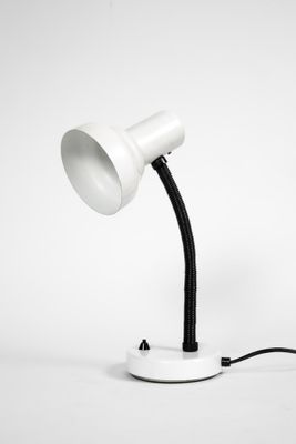 une image représentant une lampe de bureau blanche posée sur une surface blanche