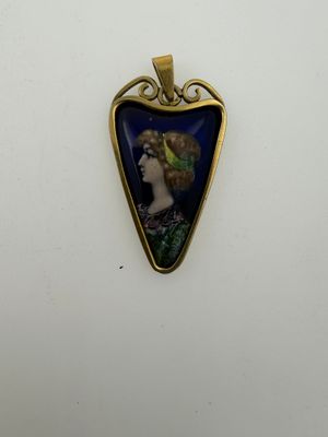 a close up of a pendant with a woman ' s face on it