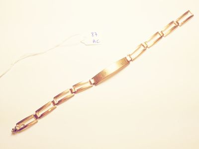 a gold bracelet on a white surface with a price tag