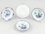 four pieces of blue and white china on a white background