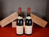 two bottles of wine are sitting on a table with a wooden box