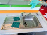 a kitchen sink with a pair of blue gloves on it