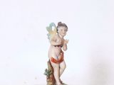une petite figurine représentant un Cupidon posée sur une étagère