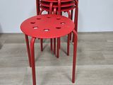 quatre tabourets rouges posés sur un parquet en bois massif