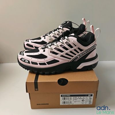 the shoe box is full of a pair of pink and black sneakers