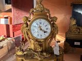 une horloge en or posée sur une table dans une pièce