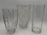 three glass vases sitting next to each other on a white surface