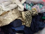 a pile of clothes in a bag on a bed