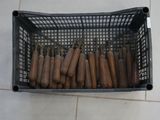 a lot of hot dogs in a basket on the floor