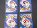 four pokemon cards are sitting on top of a table
