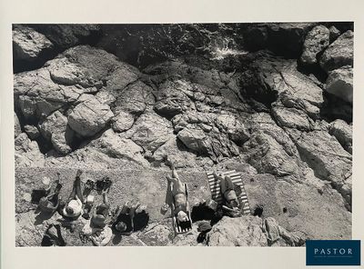 photographie en noir et blanc d'un groupe de personnes assises sur un rocher