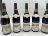 four bottles of wine are lined up on a table