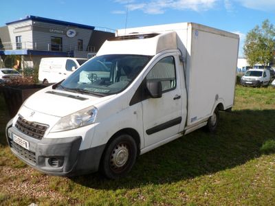 une petite camionnette blanche garée dans un champ herbeux