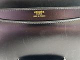 a close up of a black purse on a white surface