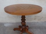 une petite table avec un plateau en bois sur un sol en béton