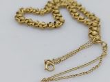 a close up of a gold chain on a white surface