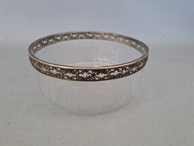 un bol transparent bordé d'or posé sur une table blanche