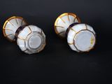 pair of white and gold vases on a black background