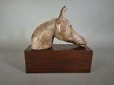sculpture of a horse ' s head on a wooden base