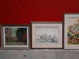 three framed pictures on a ledge in front of a red wall