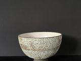 a white bowl sitting on top of a black table