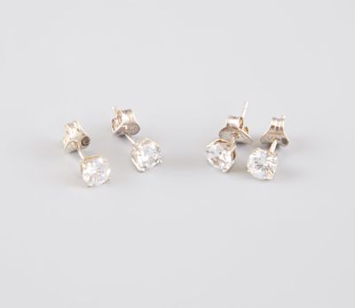 a pair of diamond stud earrings on a white background