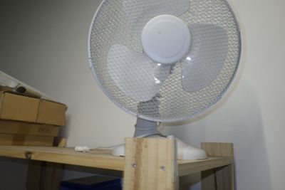un éventail blanc posé sur une table en bois