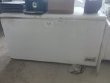 a small white refrigerator in the corner of a room