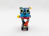 a close up of a toy dog on a skateboard on a white surface