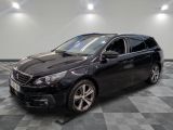 la voiture noire est garée sur un sol en damier dans le garage