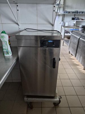 une armoire en acier inoxydable au milieu d'une cuisine dotée de nombreux plans de travail