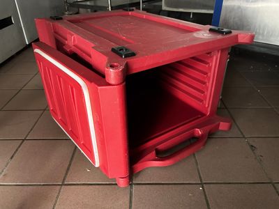 une boîte rouge posée sur un sol carrelé
