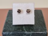 a pair of earrings sitting on top of a marble block