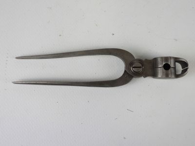 une paire de pinces posées sur une surface blanche