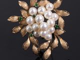 an image of a gold and pearl broochle with leaves