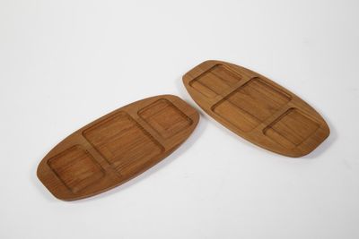 deux plateaux en bois posés sur une surface blanche