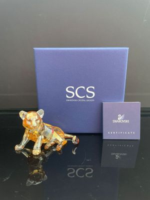 une petite figurine représentant un chat assis à côté d'une boîte bleue