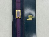une montre violette dans un coffret noir, à côté d'un coffret vert