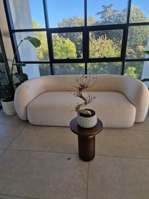 a white couch sitting in front of a window next to a table