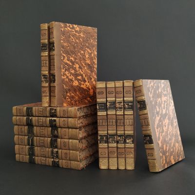 several old books stacked on top of each other on a table