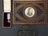 une photo représentant une médaille et un coffret à médailles posés sur une table