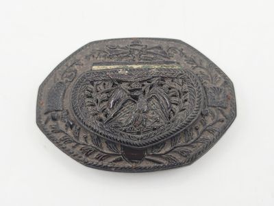 une boucle de ceinture en métal noir ornée d'un motif