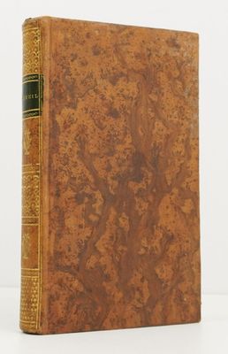 a book with a brown cover sitting on top of a white table