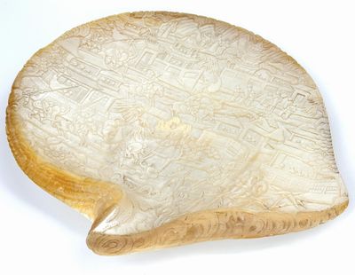 une image représentant un plat en ivoire sculpté en forme de cœur posé sur une surface blanche