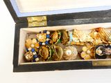 une boîte en bois remplie d'une multitude de bijoux de toutes sortes