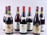 plusieurs bouteilles de vin sont alignées sur une surface blanche