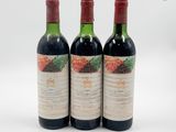 trois bouteilles de vin rouge posées l'une à côté de l'autre sur une surface blanche