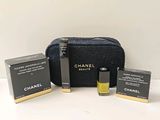 une trousse de maquillage Chanel avec trois flacons de parfum à côté