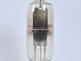 a glass tube with a wooden base on a white surface